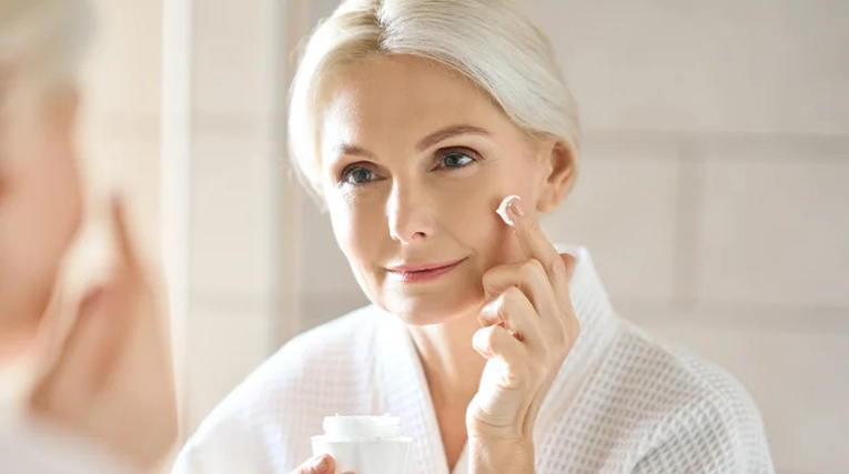 older woman wiping her face skin care routine