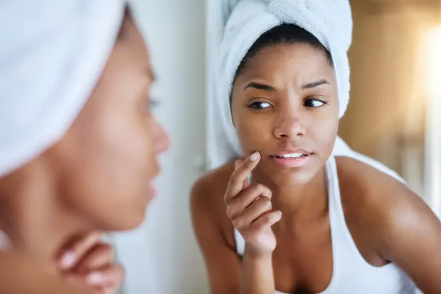 woman looking at herself in mirror | Geria dermatology