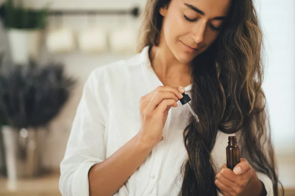 woman putting oil in her hair