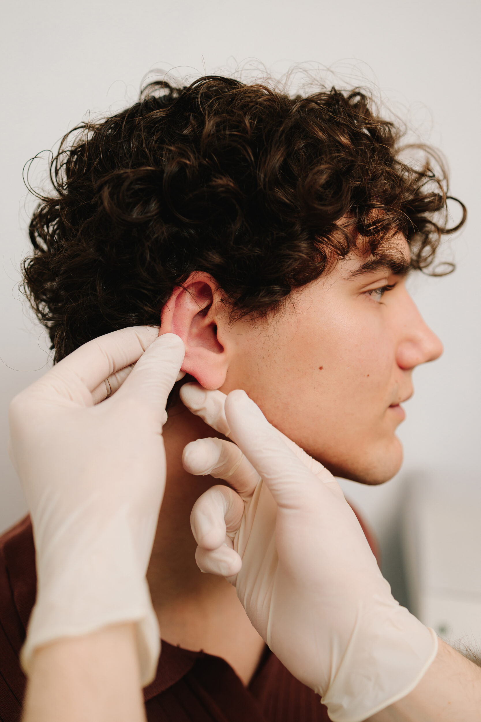 Otoplasty for changing the shape, position or size of the ears. Surgeon doctor examines ear of male patient before otoplasty surgery. Earlobe Repair In New Jersey | Geria Dermatology